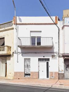 een wit gebouw met een deur en een balkon bij CASA EN LA PLAYA VALENCIA EL PERELLO in Mareny Barraquetas