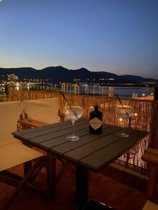 two wine glasses sitting on a table on a deck at Guest house del Mar in Iraklitsa