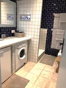 a bathroom with a washing machine and a shower at Logement calme avec vue sur le Luberon in Saignon