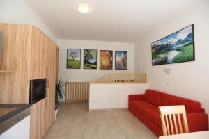 ein Wohnzimmer mit einem roten Sofa und Bildern an der Wand in der Unterkunft Haus Lienbacher in Flachau