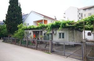 a house with a fence with vines on it at Apartments Boris in Budva