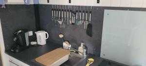 a kitchen counter with utensils hanging on a wall at La cabane Oléronnaise in Saint-Pierre-dʼOléron