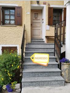 コー​​ニュにあるLivio & Giannaの家の階段に座る黄色の看板