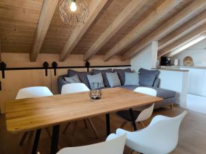 ein Esszimmer mit einem Holztisch und weißen Stühlen in der Unterkunft Chesa Piz in Pfronten