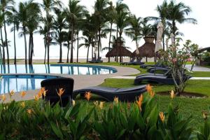 a resort with a pool and palm trees at El descanso del guerrero in Barra Vieja