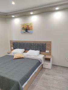 a bedroom with a large bed in a room at Flowers Apartment in Dobrich