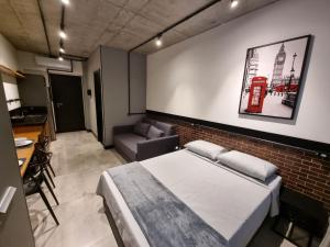 a bedroom with a bed and a brick wall at APTO Studios in Itajaí