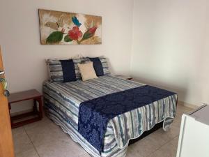 1 dormitorio con 1 cama y una pintura en la pared en Estancia Maria, en Pirenópolis