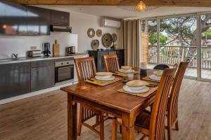 uma cozinha e sala de jantar com uma mesa de madeira e cadeiras em Mamita 3"Salty dreams apartment"spacious and bright T3 84m 35m terrace em Lacanau-Océan