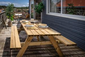 - une table de pique-nique en bois sur la terrasse couverte d'une maison dans l'établissement Mamita 3"Appartement rêves salés"spacieux et lumineux T3 84m35mterrasse, à Lacanau-Océan