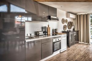 a kitchen with stainless steel appliances and wooden floors at Mamita 3"Salty dreams apartment"spacious and bright T3 84m 35m terrace in Lacanau-Océan +11 photos