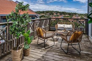 a patio with chairs and a table on a deck at Mamita 3"Salty dreams apartment"spacious and bright T3 84m 35m terrace in Lacanau-Océan