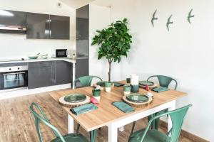a kitchen and dining room with a wooden table and chairs at Mamita 4 "wooded stopover apartment" T2 47m terrace 24m in Lacanau-Océan