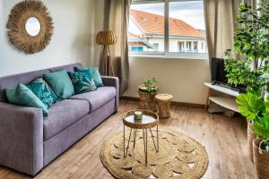 a living room with a purple couch and a table at Mamita 4 "wooded stopover apartment" T2 47m terrace 24m in Lacanau-Océan