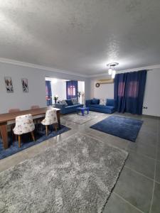 a living room with a couch and a table and chairs at Spacious 3 bedroom apartment - FAMILIES ONLY in 6th Of October