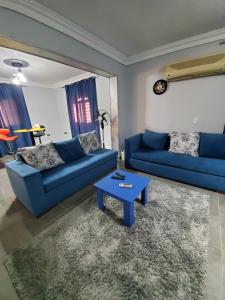 10月6日市にあるSpacious 3 bedroom apartment - FAMILIES ONLYの青いソファ2つとテーブルのあるリビングルーム