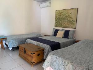 Cette chambre comprend 2 lits jumeaux et une table. dans l'établissement Estancia Maria, à Pirenópolis