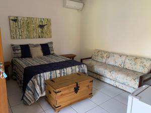 - une petite chambre avec un lit et un canapé dans l'établissement Estancia Maria, à Pirenópolis