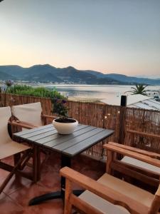 a table and chairs on a balcony with a view of the water at Guest house del Mar in Iraklitsa