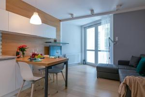 a kitchen and living room with a table and a couch at Apartament Muszelka Jantar TriApart in Jantar