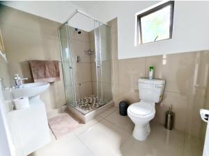 a bathroom with a shower and a toilet and a sink at Oyster Guest House in Durban +38 photos
