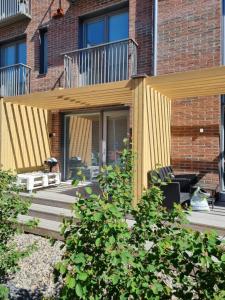 a wooden pergola on a patio in front of a building at Culture center of Oulu studio in Oulu