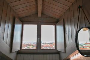 a mirror in a bathroom with two windows at Cibrario Cit Apartment_Square in Turin