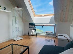 a living room with a large window and a stool at Apartamentos LAMAROSA -ATICO ,Vistas al Mar Cantabrico PARKING in Burela de Cabo