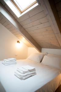 a bedroom with a white bed with a skylight at Cibrario Cit Apartment_Square in Turin