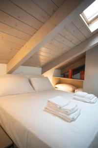 a bed with two folded towels on top of it at Cibrario Cit Apartment_Square in Turin