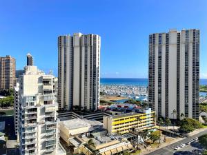 two tall buildings in a city next to the ocean at Ala Moana 1826 condo in Honolulu