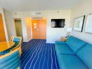 a living room with a blue couch and a table at Ala Moana 1826 condo in Honolulu