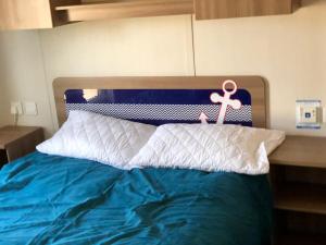 a bed with a blue and white headboard with a pink anchor at The Populars, 18 in Rhyl