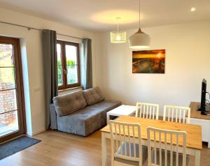 salon z kanapą i stołem w obiekcie Apartament z ogrodem w Sarbinowie