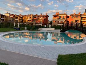 a large swimming pool with a bridge and some buildings at Appartamento Emerald in Sirmione