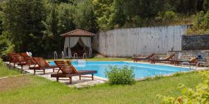 un gruppo di sedie a sdraio accanto alla piscina di Habitat Villa Corfu a Dassia