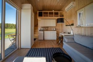 a living room and kitchen in a tiny house at Aitvaru Terasos in Svenele