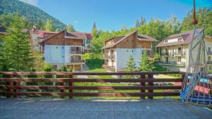 a village with houses and a wooden fence at The Mountain Villa in Poiana Brasov