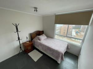 a small bedroom with a bed and a window at Neohaus vista insuperable in La Serena