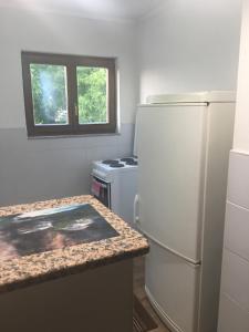 a kitchen with a white refrigerator and a stove at Cozy 2 bedroom apartment in Sarajevo