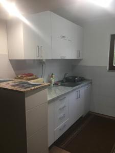 a kitchen with white cabinets and a sink at Cozy 2 bedroom apartment in Sarajevo