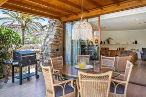 un patio con mesa, sillas y parrilla en Gran Tauro Villa en La Playa de Tauro