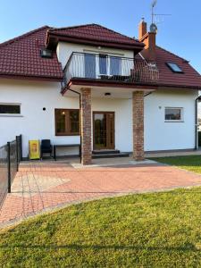 Biały dom z ceglanym patio w obiekcie Apartament z ogrodem w Sarbinowie