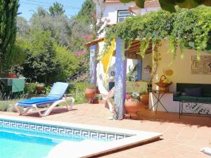 un patio con una silla junto a una piscina en Adore Portugal Lousã Casa Rural 2 Suites, en Lousã