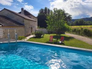 a swimming pool in front of a house at Le Clos des Figuiers - 3 Gîtes de caractère in Duravel