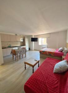 a room with two beds and a kitchen with a table at Hostel Penedes in Vilafranca del Penedès
