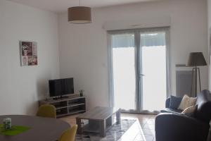 a living room with a couch and a table and a tv at Villa Saint Fort - Résidence Services in Saint-Fort