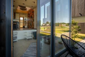 a screened in porch with a kitchen and a patio at Jaukus modernios architektūros Svencelės namas in Svencelė