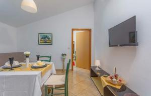 a dining room with a table and a television on a wall at Gimy Villa&App 2 Porec in Nova Vas