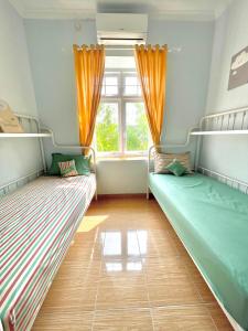 2 Betten in einem Zimmer mit Fenster in der Unterkunft Rumah Paron Homestay Barat in Yogyakarta